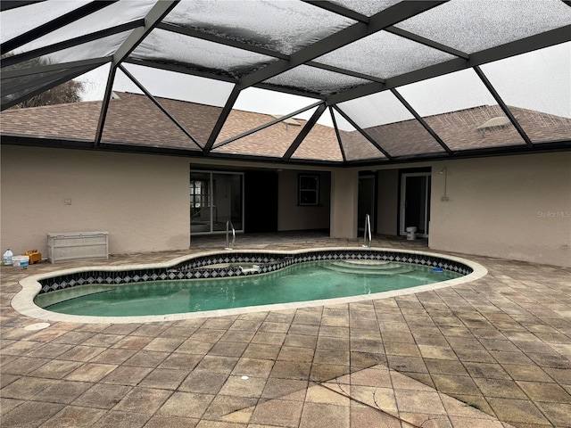 view of pool with a patio and glass enclosure