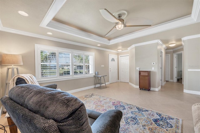 living room with light tile patterned flooring, ornamental molding, ceiling fan, and a tray ceiling