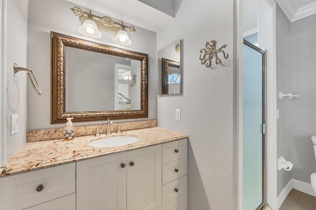 bathroom with vanity, an enclosed shower, crown molding, and toilet