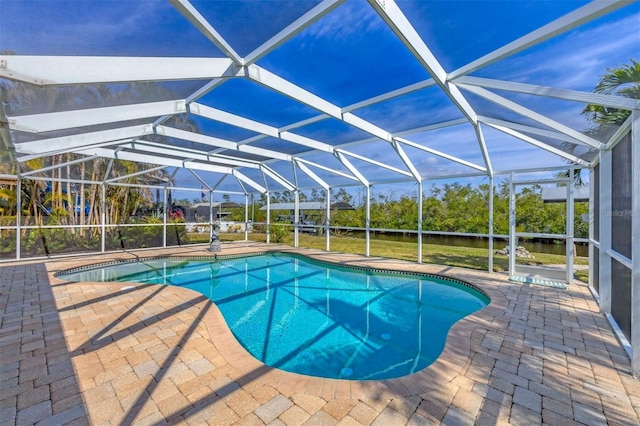 view of pool with glass enclosure and a patio area