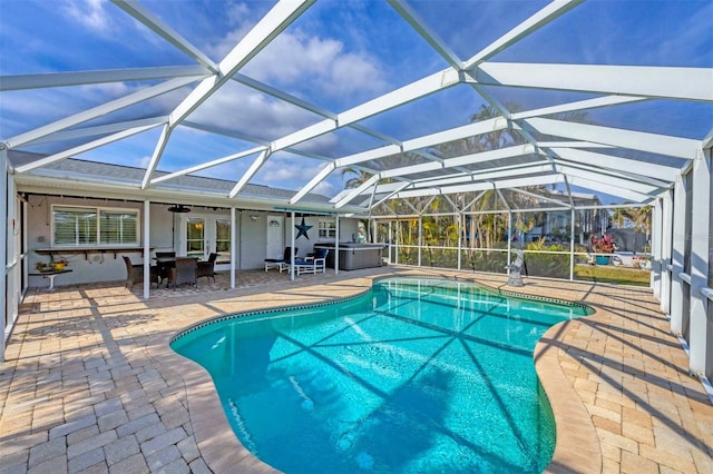 view of swimming pool featuring a lanai, a patio area, and a jacuzzi