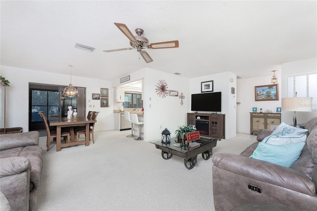 living room featuring light carpet, a textured ceiling, and ceiling fan