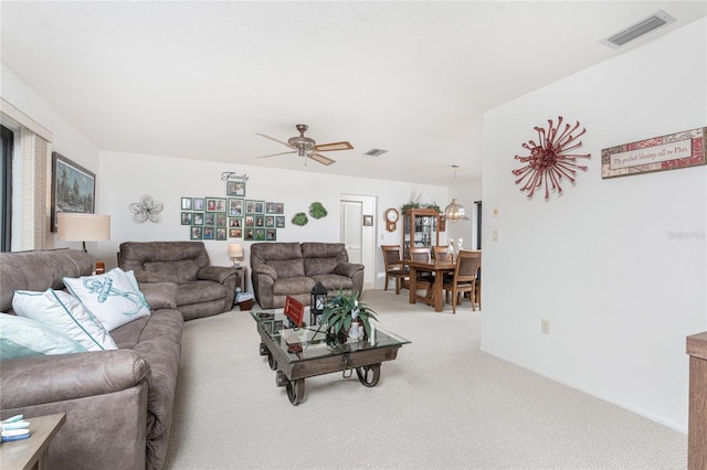 carpeted living room with ceiling fan