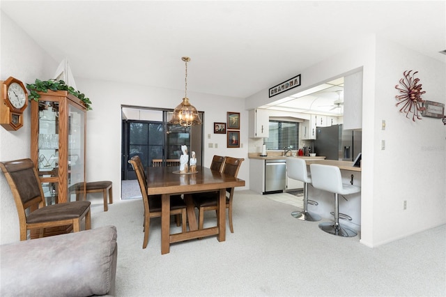 carpeted dining room with ceiling fan with notable chandelier