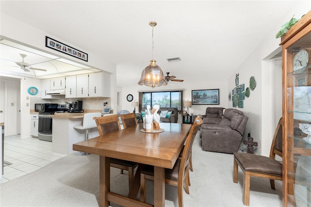 carpeted dining area featuring ceiling fan with notable chandelier