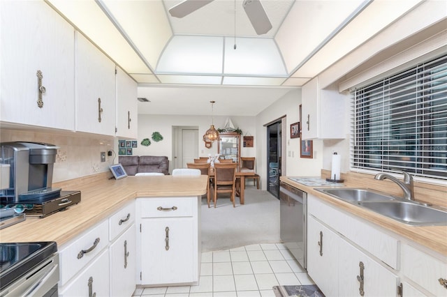 kitchen featuring sink, dishwasher, hanging light fixtures, white cabinets, and light carpet