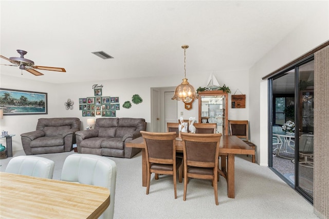 dining space featuring ceiling fan with notable chandelier and carpet floors