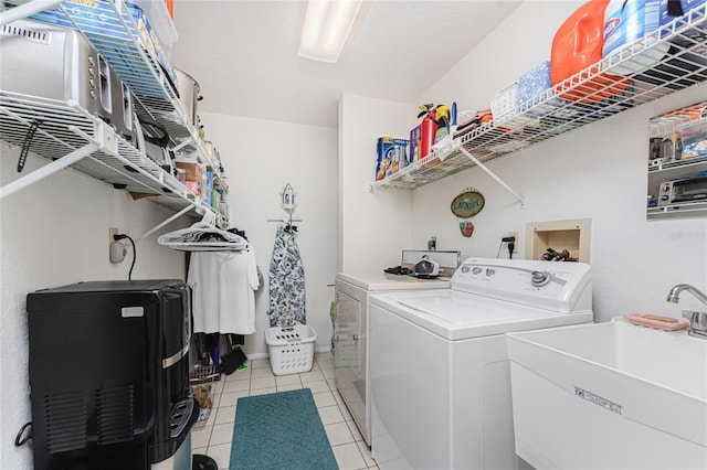 laundry room with sink, washing machine and clothes dryer, and light tile patterned flooring