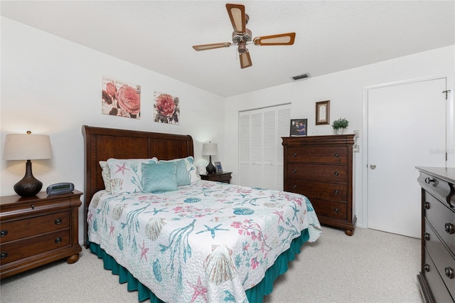 bedroom featuring ceiling fan, light carpet, and a closet