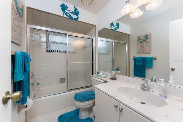 full bathroom featuring tile patterned flooring, vanity, shower / bath combination with glass door, and toilet