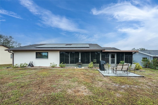 back of house with a lawn, a sunroom, and solar panels