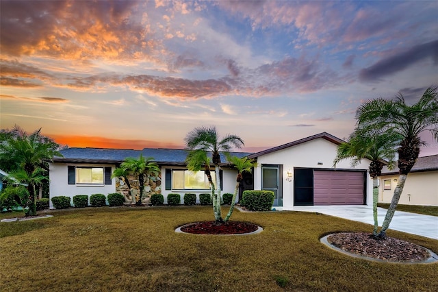 ranch-style home with a garage and a lawn