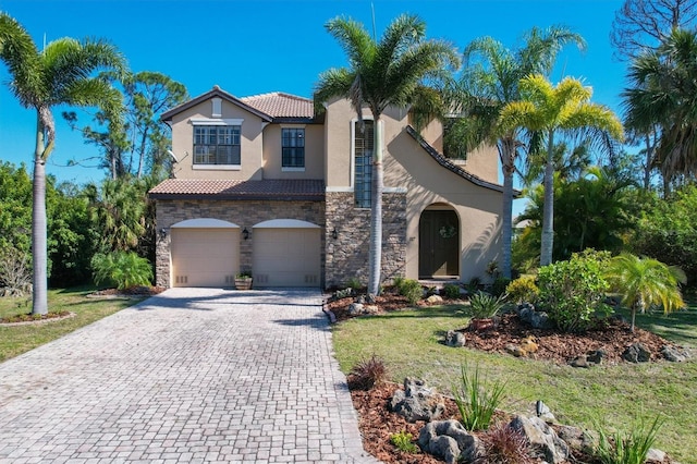 mediterranean / spanish house featuring a garage and a front yard