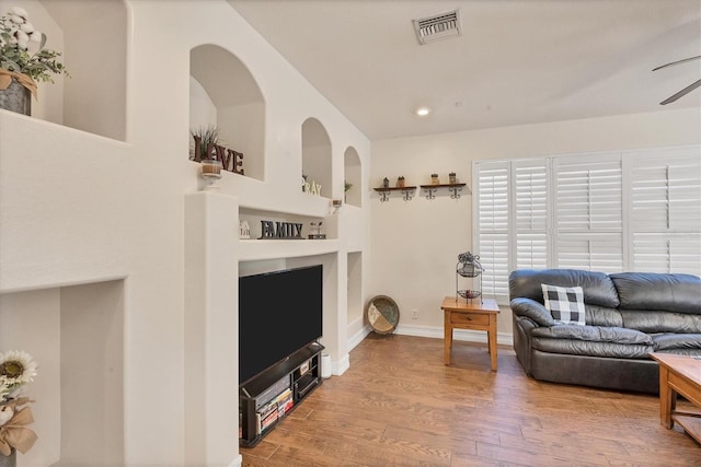 living area with visible vents, a ceiling fan, wood finished floors, built in shelves, and recessed lighting