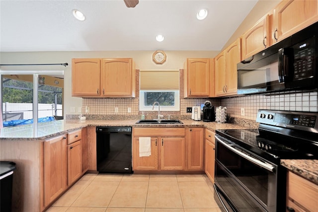 kitchen with sink, light tile patterned floors, light stone counters, black appliances, and light brown cabinets