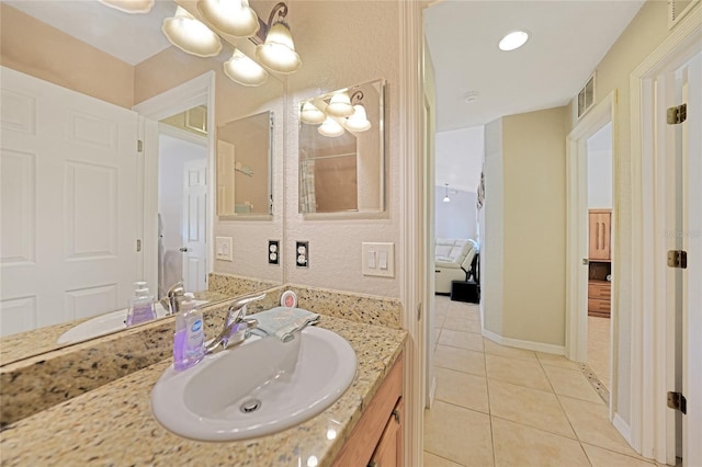 bathroom featuring tile patterned flooring, vanity, and a chandelier