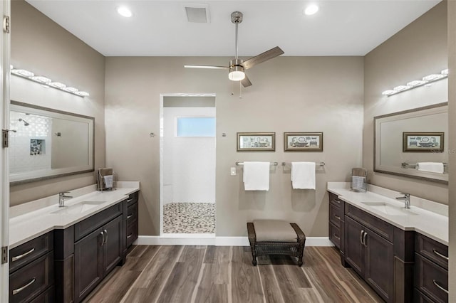 bathroom with ceiling fan, vanity, hardwood / wood-style floors, and a tile shower