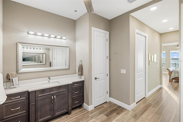 bathroom with vanity, hardwood / wood-style flooring, and ceiling fan