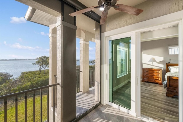 balcony with a water view and ceiling fan