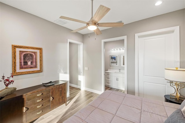 bedroom featuring sink, ensuite bath, light hardwood / wood-style floors, and ceiling fan