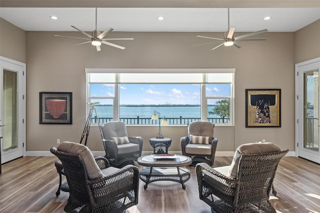 living room with a water view, ceiling fan, and hardwood / wood-style flooring