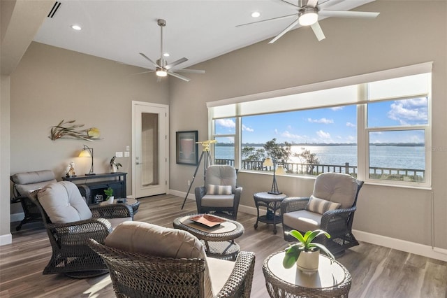 living room featuring hardwood / wood-style flooring, ceiling fan, and a water view