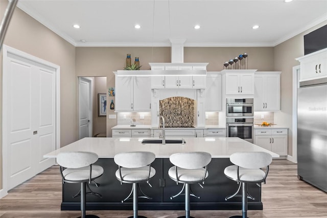 kitchen with white cabinetry, sink, an island with sink, and appliances with stainless steel finishes