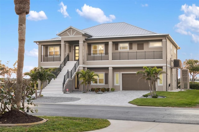 9861 Eagle Preserve Dr, Englewood, FL 34224 - view of front facade featuring stucco siding, stairway, decorative driveway, and an attached garage