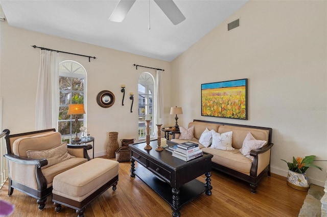 living room with hardwood / wood-style flooring, ceiling fan, and vaulted ceiling