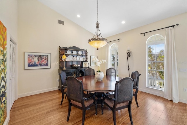 dining room with vaulted ceiling and light hardwood / wood-style floors