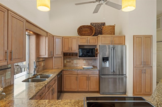 kitchen with tasteful backsplash, sink, light tile patterned floors, light stone counters, and black appliances