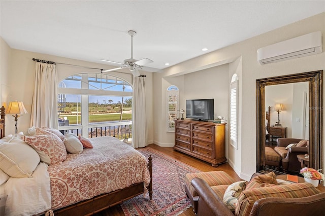 bedroom with ceiling fan, light hardwood / wood-style floors, and a wall mounted AC