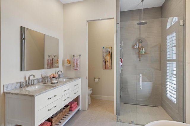 bathroom with walk in shower, vanity, and toilet