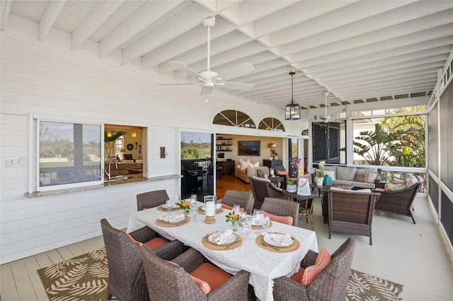 sunroom / solarium with beamed ceiling and ceiling fan