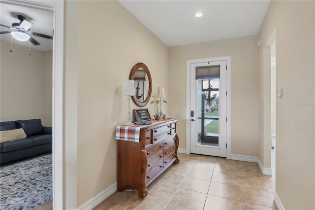 entryway featuring a ceiling fan, light tile patterned flooring, and baseboards