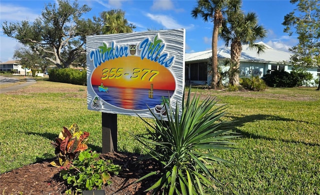 community sign featuring a lawn