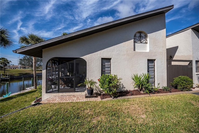 rear view of house with a water view and a yard