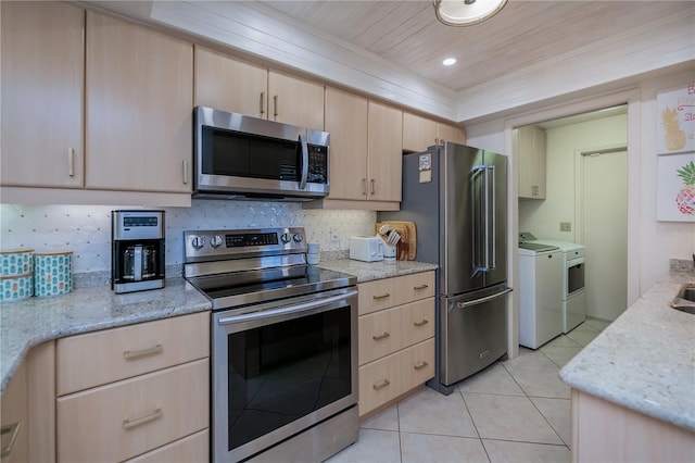 kitchen featuring stainless steel appliances, independent washer and dryer, light stone countertops, light tile patterned flooring, and light brown cabinets