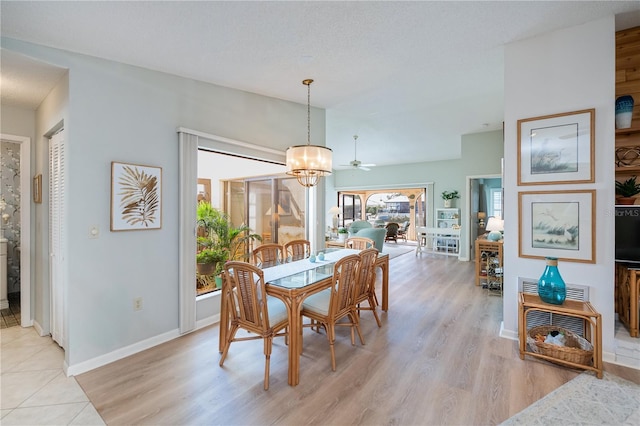 dining area with an inviting chandelier, a textured ceiling, and light hardwood / wood-style floors