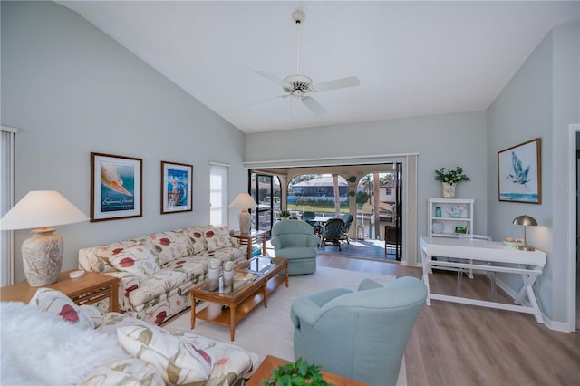 living room featuring ceiling fan, high vaulted ceiling, and light wood-type flooring