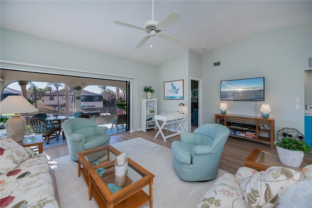 living room featuring vaulted ceiling, ceiling fan, and light wood-type flooring