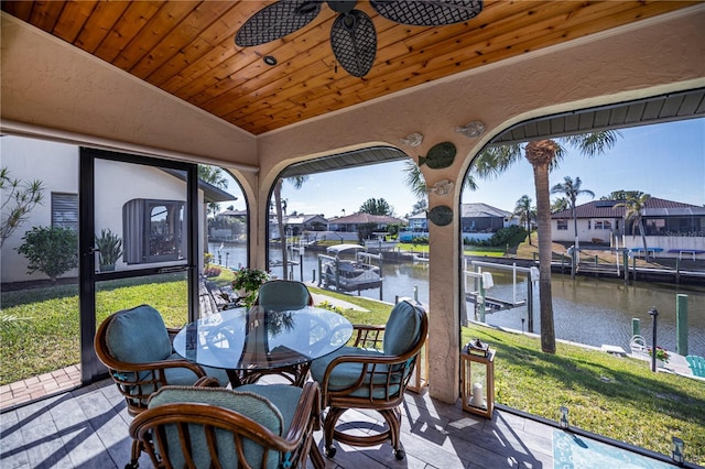 sunroom featuring a water view, ceiling fan, vaulted ceiling, and wooden ceiling