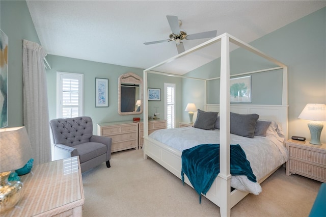 bedroom featuring ceiling fan, vaulted ceiling, light carpet, and a textured ceiling