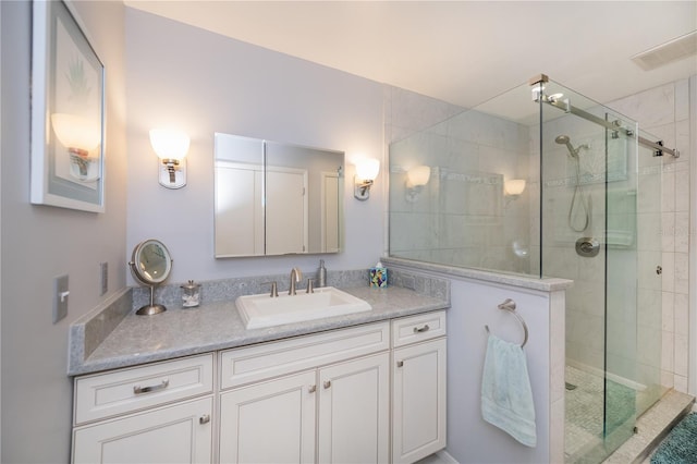 bathroom featuring vanity and a shower with shower door