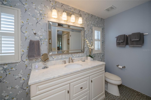 bathroom with vanity, a textured ceiling, and toilet