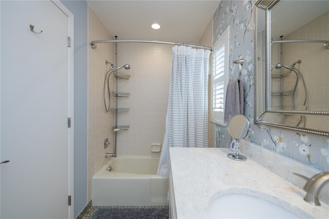 bathroom with shower / bathtub combination with curtain, vanity, and a textured ceiling