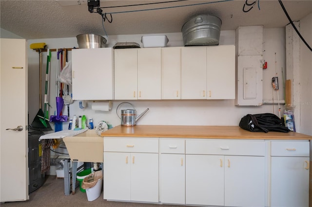 kitchen featuring white cabinetry and a textured ceiling