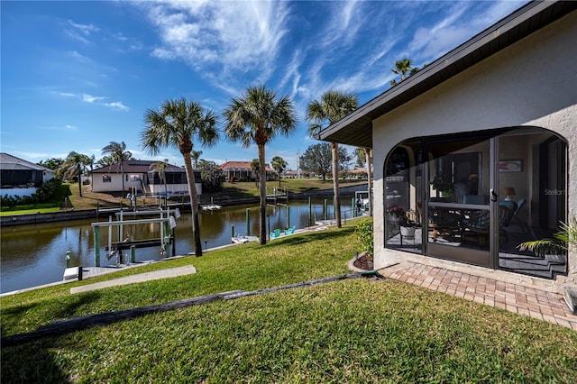 view of yard with a water view and a boat dock