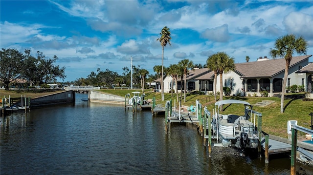 view of dock with a water view and a yard