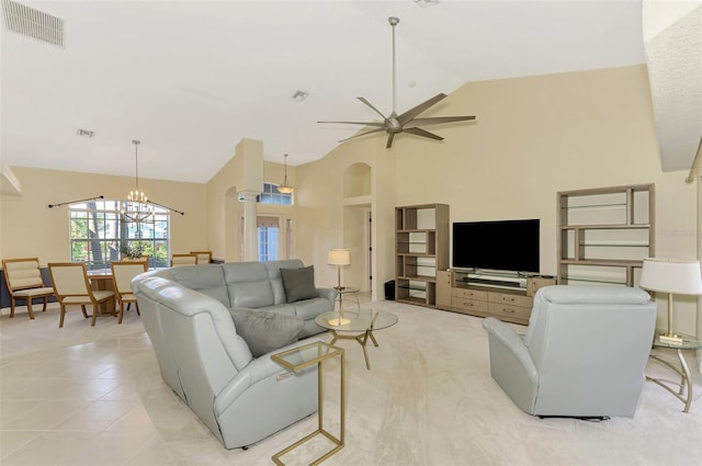 living room with light tile patterned flooring, ceiling fan with notable chandelier, and high vaulted ceiling